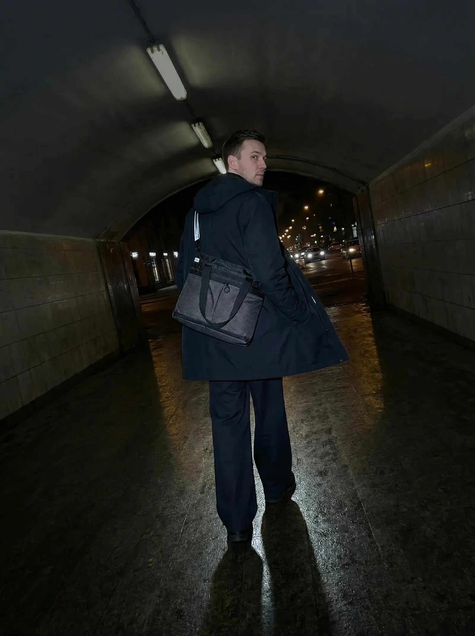 Man with bag in urban tunnel